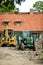 In the farmhouse yard stands excavator and a tractor with a trai