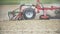 Farming background. Farmer cultivating field using harrows - slowmotion shoot.