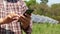 Farming man holding a black smartphone Used to control solar panels