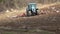 Farming: plowing. Tractor in a field followed by flying birds