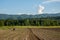 Farming with tractor and plow in field with mountain Papuk in th