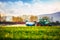 Farming tractor plowing and spraying on the green field