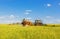 Farming tractor spraying green field