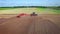 Farming tractor with trailer plowing agricultural field. Rural economy