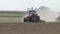 Farming tractors moving on agricultural field for plowing land. Agricultural tractor plowing farming field