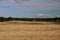 Farmland View with Wheat Field and Hay Bales
