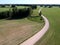 Farmland wirh white gravel road in spring, aerial view