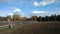 Farmland with a wooden fence under a cloudy sky with the sun shinning through