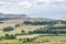 Farmlands and trees by the sea panorama, distant view of land by the ocean in United Kingdom, cloudy sea and green