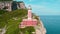 Faro di Punta Carena historic red lighthouse stands guard on a rugged cliffside on the island of Capri. Iconic structure