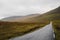 Faroe Islands, Streymoy. Spectacular view on yellow and brown hills with empty road. Moody foggy sky