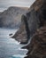 Faroe Islands, Vagar. View on black cliffs towering above the Atlantic ocean. Black cliffs formation