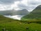 Faroe Islands. View over the bay and Funnings kommuna. Green grass fields and grazing sheeps in the foreground