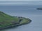 Faroe Islands. View over the village on the slope of hills. Ocean.