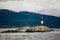 Farol Les Eclaireurs, a red and white striped lighthouse on rocky island on the Beagle Channel, Ushiaia, Argentina