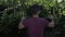 Fascinated teenager with VR set exploring green recreational area testing virtual reality technology in slow motion -
