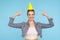 Fascinating cute happy woman in denim jacket pointing at funny party cone on her head and smiling at camera