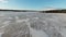 Fascinating speedy video from FPV drone flying over melting frozen lake, original sound included. Many snow mobile traces on old