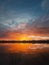 Fascinating sunset reflecting on the lake surface. Idyllic landscape, vertical background. Silent and tranquil evening scene with