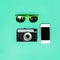 Fashion accessory. Sunglasses, vintage camera and smartphone on green background, top view. Trendy colorful photo