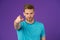 Fashion athlete point finger on violet background. Athletic man in blue tshirt on purple backdrop. Sportsman with beard on unshave