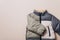 Fashion baby colorblock puffer jacket on grey background. Top view, flat lay. Newborn beige clothes outfit. Winter