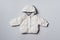 Fashion baby hooded puffer jacket on grey background. Top view, flat lay. Newborn beige clothes outfit. Winter, autumn