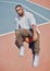 Fashion, basketball court and model influencer or man posing on a court in an urban city with fashionable style. Male