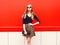 Fashion beautiful woman in leopard skirt sunglasses handbag clutch posing over red colorful