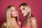 Fashion beauty portrait of two beautiful women models with trendy makeup and blonde hair on pink background