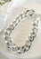 Fashion bijouterie - large silver chain bracelet on a white stand