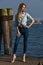 Fashion blonde model posing on the pier against the water.