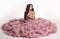 Fashion brunette pretty woman in gorgeous long pink dress posing