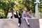 Fashion children girls posing with skate board and penny board on sport ramp on playground. Friends girls chatting