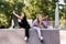 Fashion children girls posing with skate board and penny board on sport ramp on playground. Friends girls chatting