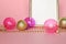 Fashion Christmas ornaments on pink background Gold picture frame with glass decorations, baubles, beads