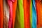 Fashion clothes on clothing rack - bright colorful closet. Close-up of rainbow color choice of trendy female wear