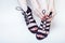 Fashion concept people: woman with red nails manicure pedicure tying shoelaces on hight heel shoes on white