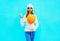 Fashion cool girl holds balloon in a white hat, sweater on blue
