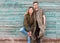 Fashion couple standing posing near blue wooden wall