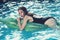 Fashion crocodile leather and girl in water. woman on sea with inflatable mattress. Relax in luxury swimming pool