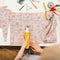 Fashion designer cuts fabric by electric saw and working in studio. View from above. Women`s hands do the job in atelier, top vie