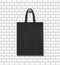 Fashion eco tote bag mockup hanging on wall background. School handbag for reusable. Black canvas sack with handles. Cotton