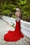 Fashion elegant blond woman model in red gown with long train of