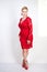 Fashion female in red lace dress standing alone. plus size blonde woman with short hair and chubby body posing in evening middle l
