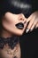 Fashion girl with black gothic hairstyle, makeup, manicure and accessories