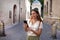 Fashion girl using smartphone app for buying museum ticket online in the medieval city of Ravenna, Italy with Dante Alighieri tomb