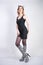 Fashion girl wearing black little dress from spandex with zebra velvet boots with high heels on white studio background