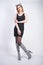 Fashion girl wearing black little dress from spandex with zebra velvet boots with high heels on white studio background