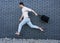 Fashion guy jumping against black brick wall with purchases, shopping